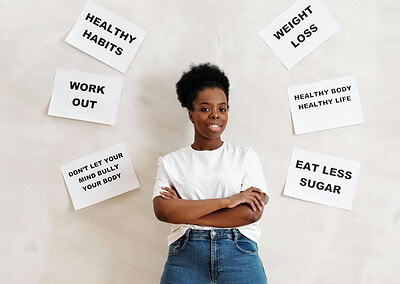 Woman standing in front of a wall with white posters labelling habits surrounding her