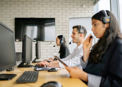 Call centre worker on headset sounding tired after a day of constant calls.