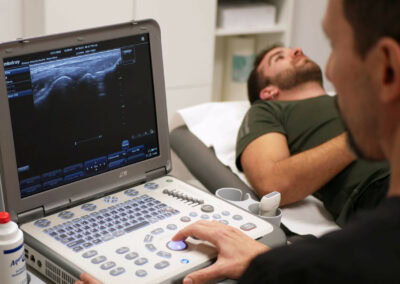 Fisioterapeuta realizando ecografía a un paciente en la clinica de Móstoles
