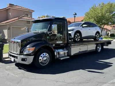 Volkswagen ID.4 electric vehicle secured on a flatbed tow truck in Phoenix