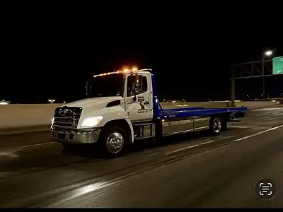 Freeway Towing & Storage flatbed tow truck en route to an emergency towing call at night on the I-10 in Phoenix, AZ