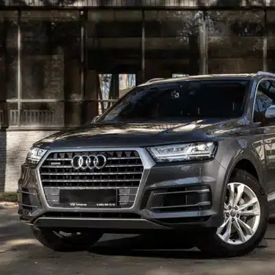 A parked Audi SUV in daylight, showcasing its sleek exterior and modern front grille