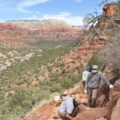 IMG_9645 cropped2 Volunteers working along the edge of a trail with red rock in the distance
