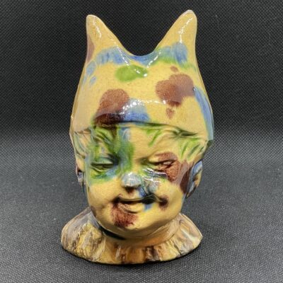 Seltene Spardose aus herrlich glasierter Keramik - 'Kind mit Eselsmütze', spätes 19. Jahrhundert