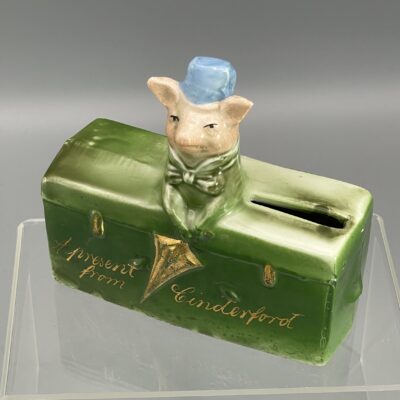 Schweinchen mit Schirm auf Truhe - "A present from Cinderford" - Spardose, Porzellan, Deutschland um 1900/1910