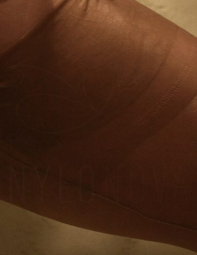 Mrs NyloNova wearing pencil skirt, beige super glossy Cuban Heel Gio Nylon Stockings. Black leather Kazar high heels.