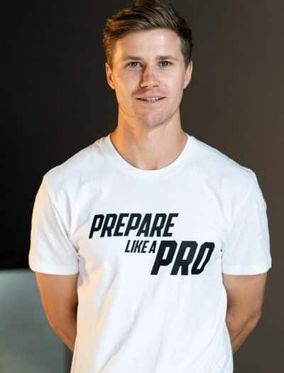 Image of Dylan Vizzarri in a white t-shirt with the text 'PREPARE LIKE A PRO' printed on it, smiling slightly and looking directly at the camera.