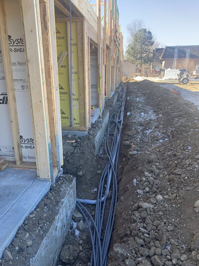 Electrical conduit placed into excavated trench for electrical contractor as part of larger construction project in Adams County, Colorado