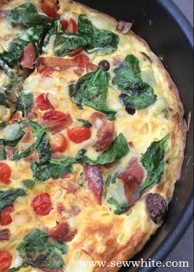 The finished Easy Fridge Raiding Omelette looking golden brown with spinach and tomatoes visible inside