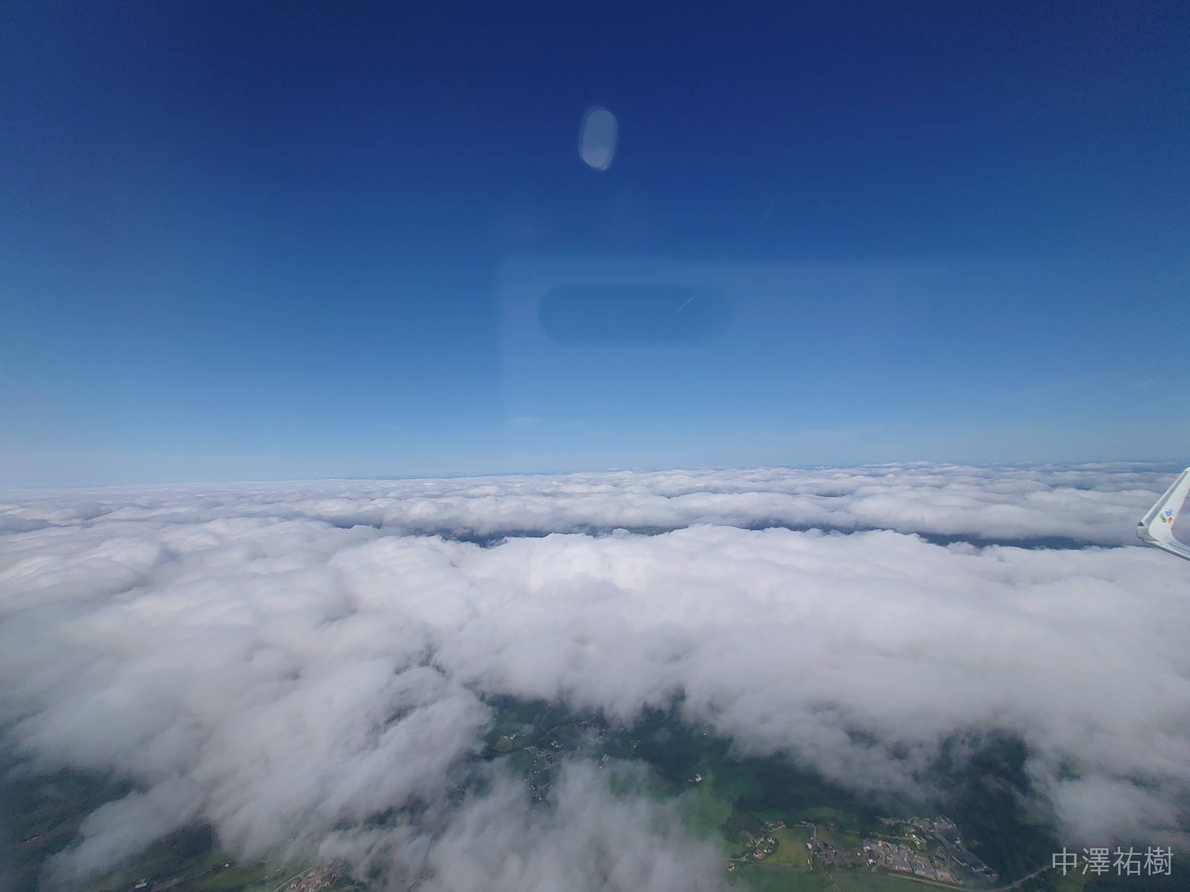 雲の隙間から地上が少し見える