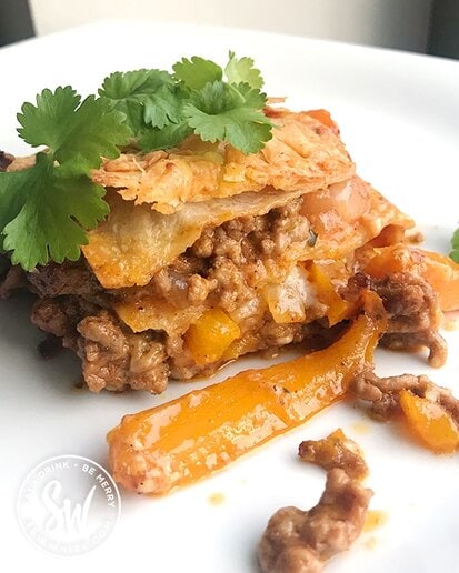 Fajita Traybake with visible layers or tortilla, peppers, been mince and onions. Mexican Lasagne topped with fresh coriander