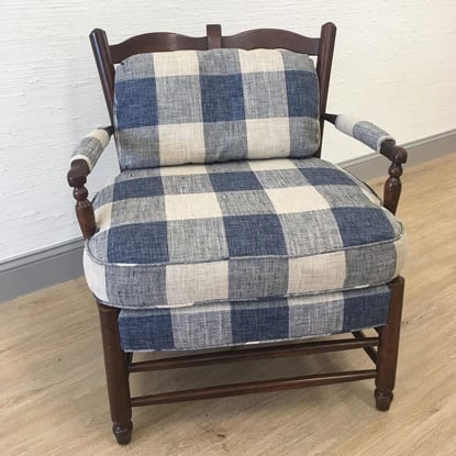 Stylish wooden armchair with plaid blue and beige fabric cushions, perfect for cozy living rooms.