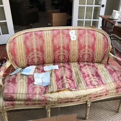 Elegant vintage upholstered sofa with pink and cream damask fabric. Classic French style furniture.