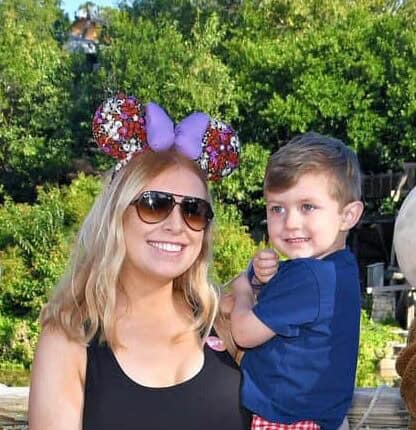 Colorful Disney-inspired Mickey Mouse ear headband with floral details and purple bow, perfect for amusement park visits.