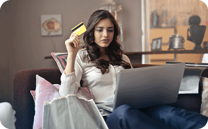 Young woman shopping online with laptop and credit card at home