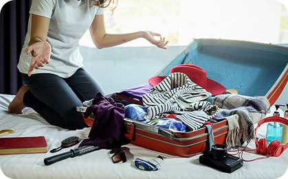 Woman unpacking shopping bags with trendy clothes and fashion accessories