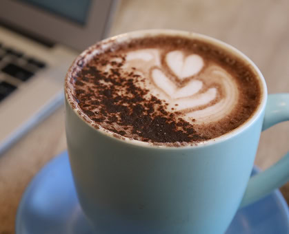 A latte decorated with foam art and dusted with cocoa suggests the kinds of offerings available with food and beverage tenants at 1000 Socials luxury Raleigh office tower
