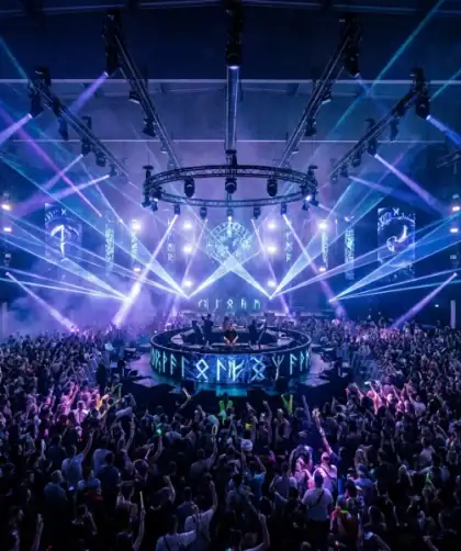 Soirée électronique immersive au Parc Expo de Caen avec scène centrale et effets lumineux spectaculaires.