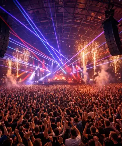 Festival techno indoor bondé avec foule de ravers dansant sous lasers colorés et pyrotechnie au Parc des Expositions.