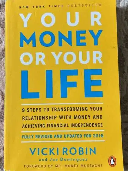 Book cover of &ldquo;Your Money or Your Life&rdquo; by Vicki Robin and Joe Dominguez. The cover is bright yellow with bold white and blue text. The subtitle reads: &ldquo;9 Steps to Transforming Your Relationship with Money and Achieving Financial Independence.&rdquo; It mentions being fully revised and updated for 2018, with a foreword by Mr. Money Mustache.