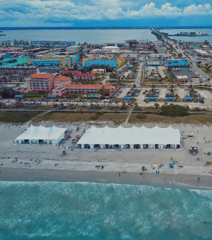 Aerial view of Melbourne Beach hotels on the beach in Florida showing oceanfront hotels, white beach tents, and coastal buildings along the shoreline