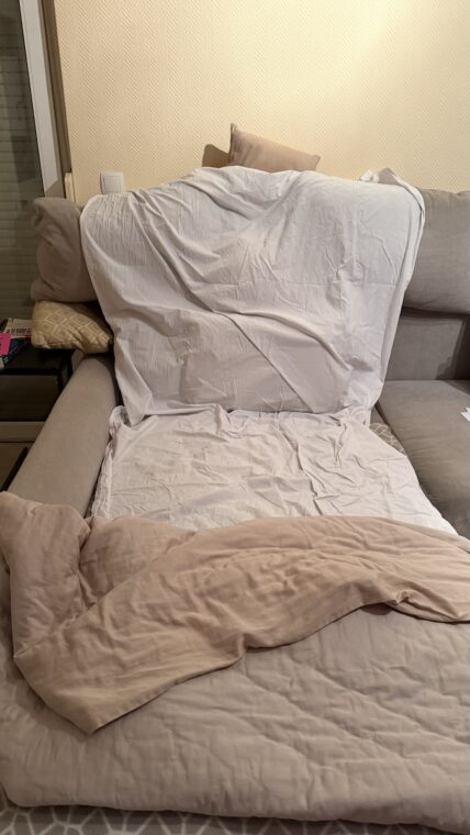 Meine Couch mit Kissen auf der Rücklehne und ein weißes Bettlaken darüber