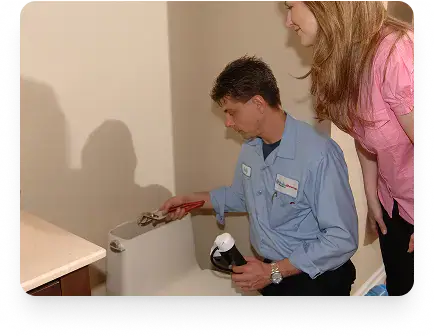 Etobicoke homeowner watching a Drain Rescue plumber fix a toilet tank