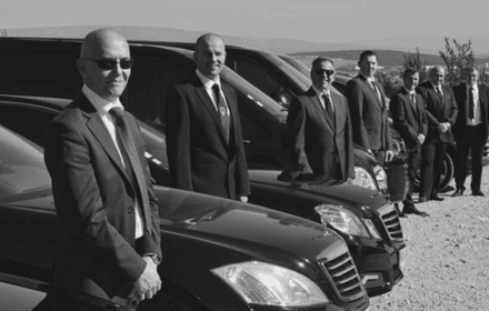 Professional safe drivers in Dubai standing next to luxury car
