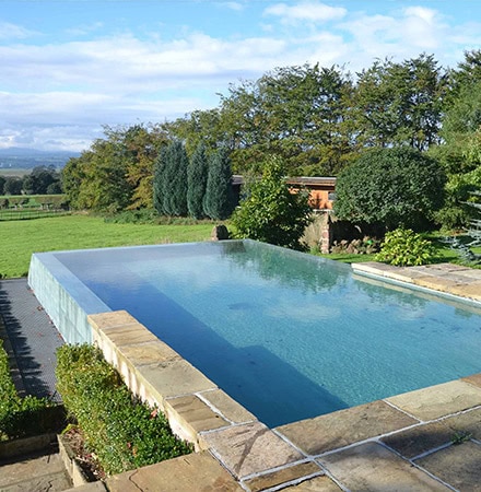 Piscine à débordement avec belle vue sur le jardin