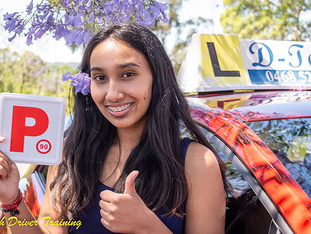 Smiling teenage student showing her fresh P-plate with purple blossoms behind her ear