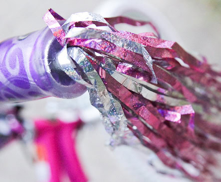 purple bike handle bar with pink streamers