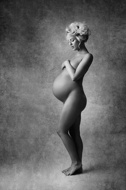 Vakker gravid kvinneharoo, svart-hvitt foto av en gravid kvinne med blomster i håret, gravidfotografering, kunstnerisk gravidfotografering for minne og feiring av graviditet, gravide portretter for kvinner, gravidfoto.