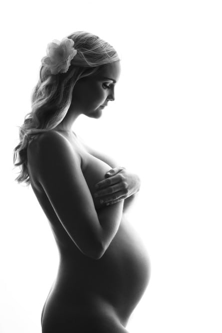 Søt gravid kvinne som holder magen, svart-hvitt bilde, gravidfotografering, morskap, forventning, kvinnelig skjønnhet.