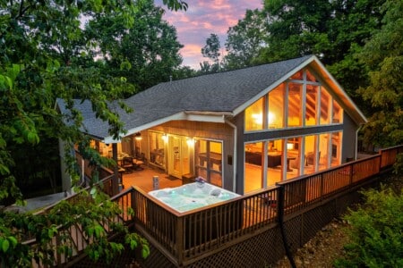 Welcome to Sunshine Around the Bend, your private Smoky Mountain escape. Cozy lights glowing from a chalet, nestled among the trees with a wraparound deck to unwind.
