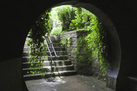 A lush green staircase under a stone archway in Eureka Springs, Arkansas.