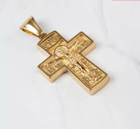 Un crucifijo dorado con San Cristóbal y detalles religiosos, símbolo de fe y protección.