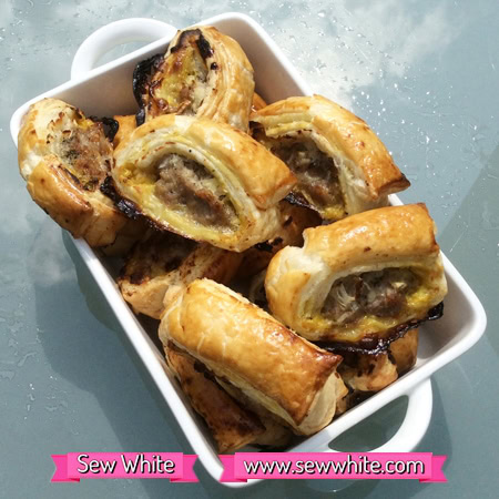 golden brown mustard sausage rolls in a white dish ready to be served