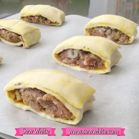 mustard sausage rolls on a baking tray ready for the oven