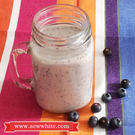 Honey and banana milkshake with blueberries in a glass