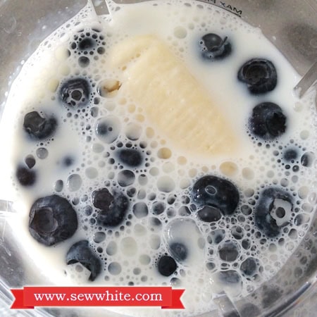 Honey and banana milkshake with blueberries in the blender