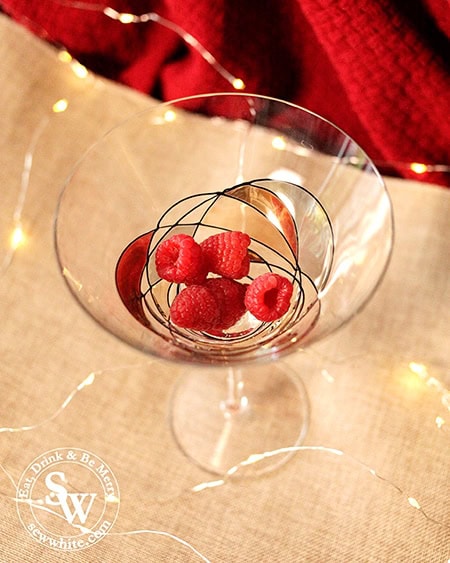 raspberries in the bottom of a glass for the Rum and Raspberry Cocktail