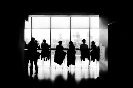 Business team collaborating in a sleek office with large window views.