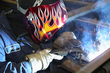 Image of a welder holding a MIG gun