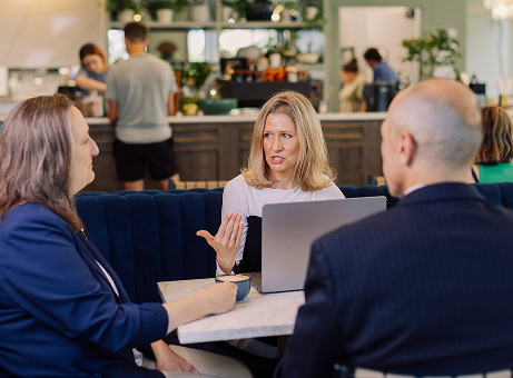 Coworkers holding an informal meeting in a cafe in the retail space of their Raleigh office tower