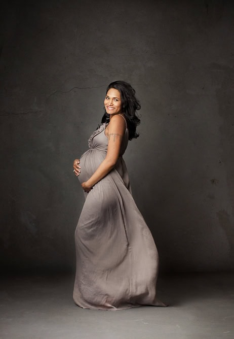 Elegant gravidfotografering av lykkelig gravid kvinne i myk gravidkjole. Naturlig gravidfoto som fanger mor og barns skjønnhet, ideell for minneverdige gravidfotografier.