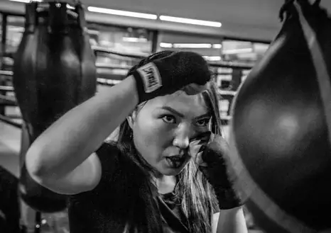 Woman boxing | Trauma symptoms | EMDR Therapy Michigan | Somatic Therapist in Detroit | Farmington Hills, MI | Southfield, MI | Royal Oak, MI A woman mid-fight stance representing the anger that occures with healing complex trauma in Farmington Hills, MI.