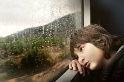 niño mirando por la ventana