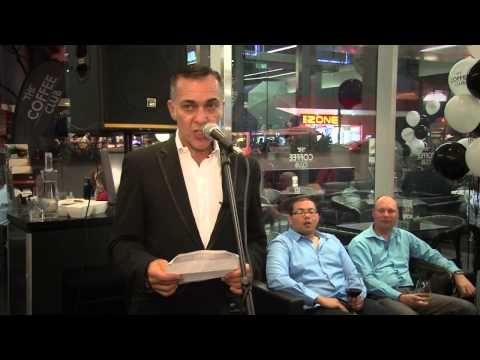 man addressing an audience at what appears to be a "The Coffee Club"