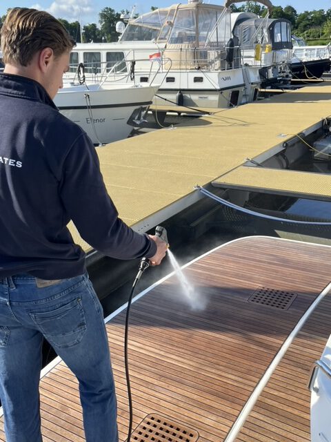 Medewerker YachtMates is teak aan het afspuiten