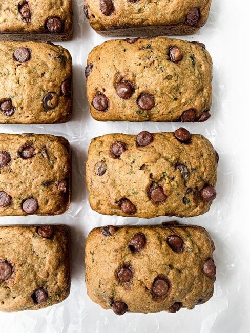 Healthy Whole Wheat Zucchini Bread with Chocolate Chips is fluffy, moist, and sneaks in some added fiber and nutrients thanks to the shredded zucchini. Made with good-for-you ingredients like coconut sugar and whole wheat flour. #wholewheat #zucchinibread #healthyrecipes #healthybaking #healthy #wholewheatzucchinibread #healthyrecipe Healthy Whole Wheat Chocolate Chip Zucchini Bread